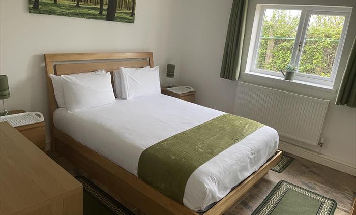 shows the king size bed, window overlooking the private garden, radiator, table lamps and 2 bedside tables.